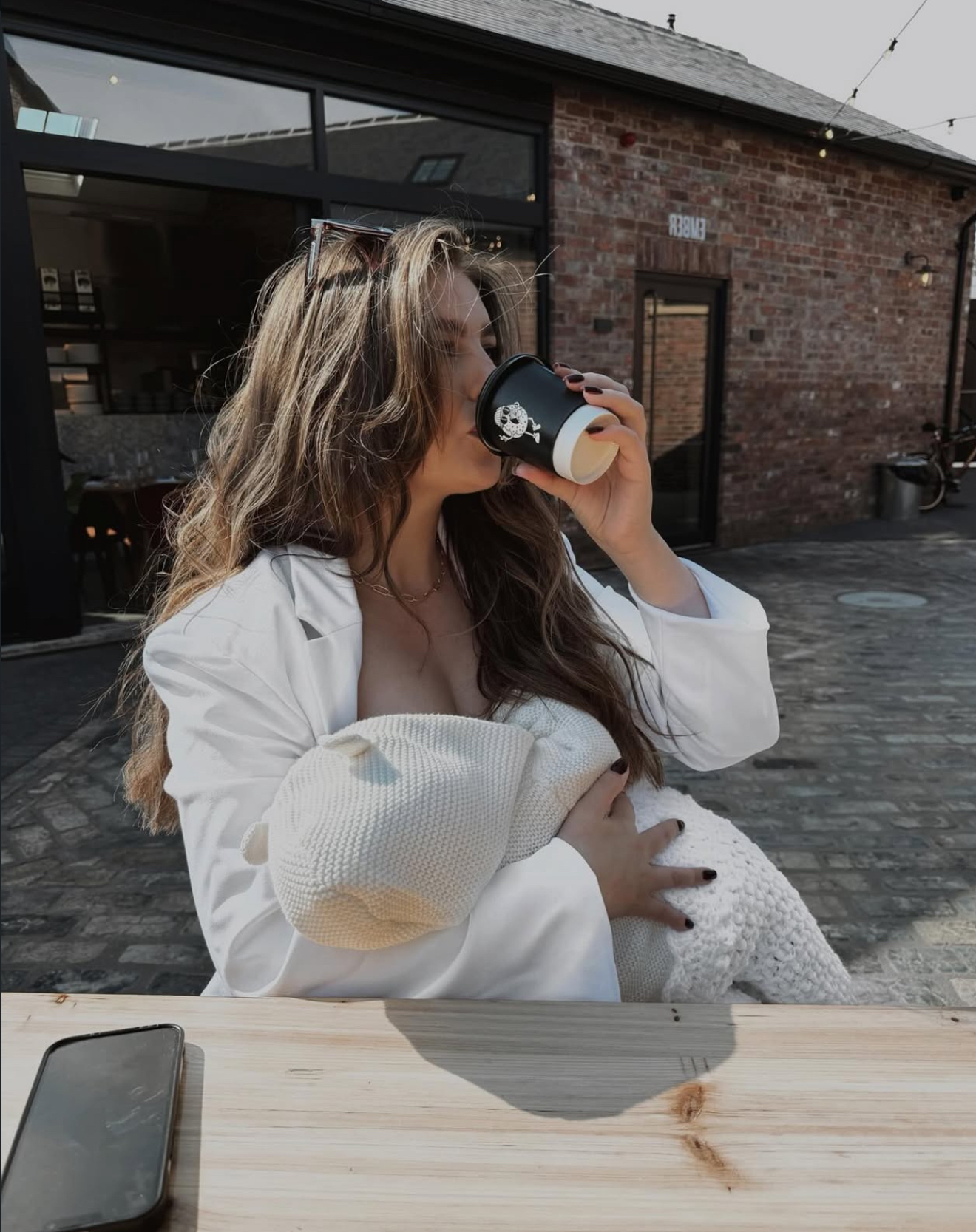 Postpartum mam enjoying a coffee whilst breastfeeding 